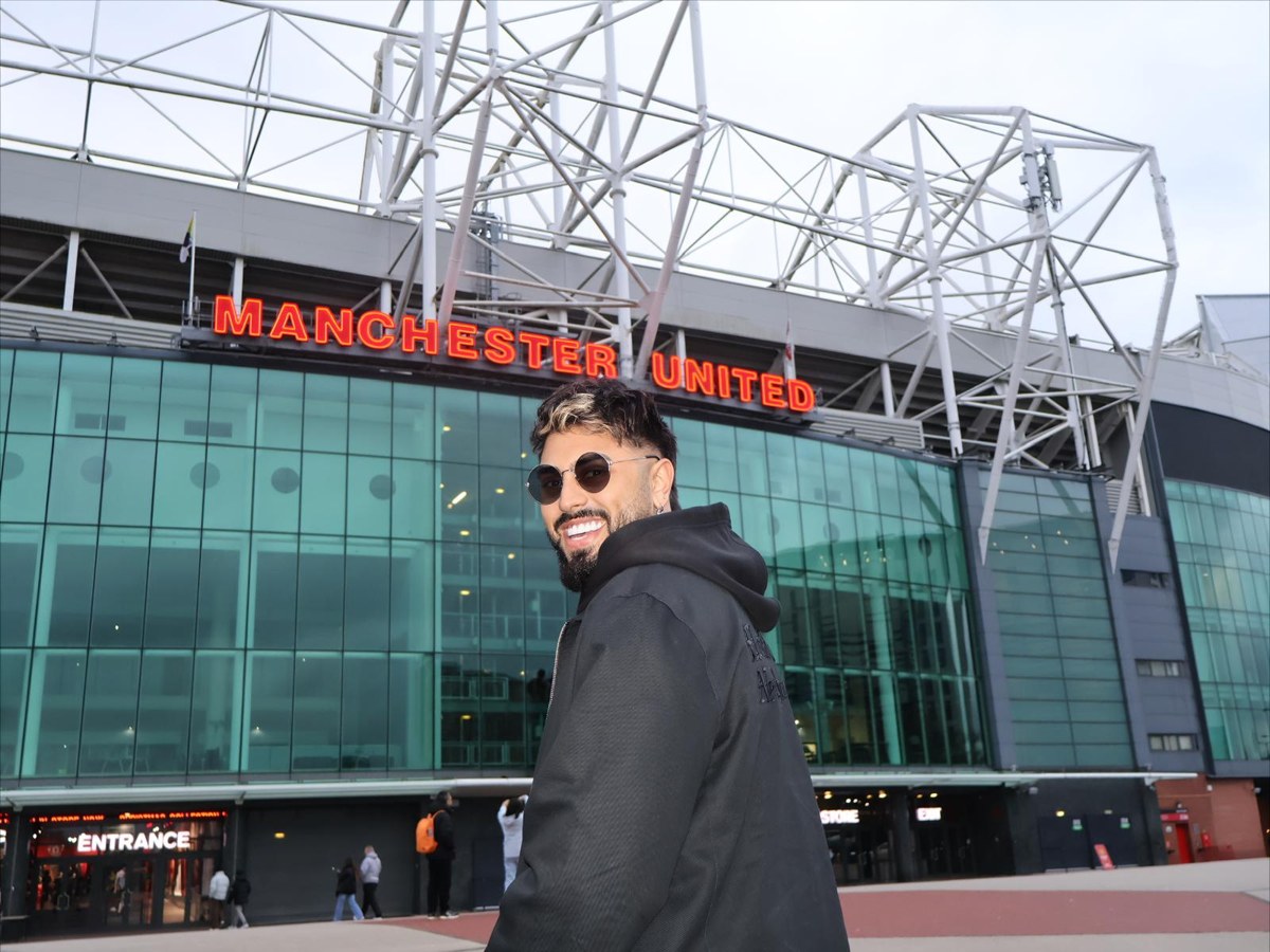 Gerryn Hussain outside Old Trafford, smiling towards the camera